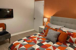 a bedroom with a bed with a colorful blanket at Luxurious House close to Rowhill Grange - Sleeps 6 in Kent