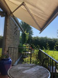 a patio with a wooden table and a roof at Aabenraa Bed in Aabenraa