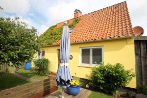 Una sombrilla de patio frente a una casa amarilla en 5085 - Haus Groß, en Dahme