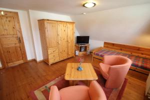 Una sala de estar con una mesa y sillas y un televisor. en 5085 - Haus Groß, en Dahme