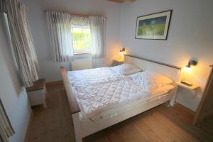 1 Schlafzimmer mit einem weißen Bett mit 2 Lampen in der Unterkunft 1000 - Lüntsches Schloss Riepsdorf in Thomsdorf