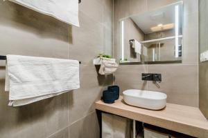 une salle de bain avec un lavabo et un miroir dans l'établissement Prague Days - Premium Loft w Terrace - View - Netflix - AC, à Prague 16 autres photos