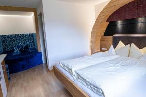 ein Schlafzimmer mit einem großen Bett mit hölzernem Kopfteil in der Unterkunft Hotel Lucia - 3 Sterne Superior in Damüls