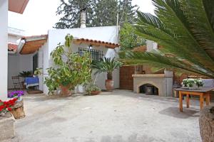 un patio de una casa con chimenea y plantas en House near the Athens Airport, Spata., en Spáta