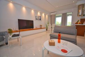 a living room with a couch and a table at Potamos Deluxe White Apartment in Potamós