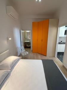 una camera da letto con un grande letto bianco e armadi arancioni di Casa vacanza Marily in centro, a 5 minuti dal mare ad Agropoli