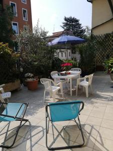 eine Terrasse mit Stühlen, einem Tisch und einem Sonnenschirm in der Unterkunft Il Platano in Como