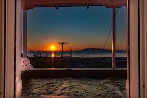 una vista di un tramonto dalla finestra di una casa di Blue Soul Luxury Villa a Éxo Goniá