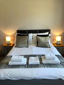 a large white bed with two towels on it at The Town House in Dornoch