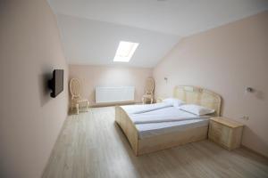 een slaapkamer met een bed en twee stoelen bij Regal Ballroom in Caransebeş +19 foto's