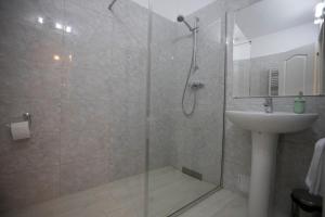 y baño con ducha y lavamanos. en Regal Ballroom, en Caransebeş