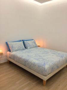 um quarto com uma cama com lençóis azuis e 2 candeeiros em Nais Home Torino em Turim