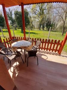 un patio con mesa, sillas y una valla en Nárcisz apartman en Gyula