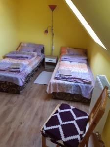2 camas en una habitación con paredes amarillas en Nárcisz apartman en Gyula