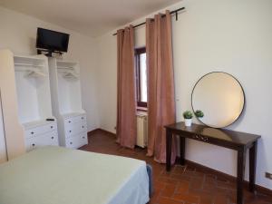 een slaapkamer met een bed en een spiegel op een tafel bij Casa Ulisse in Roccella Ionica