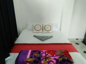 a small bed with two pillows on top of it at Sukun Guest House in Siliguri