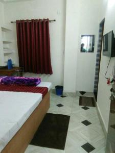 a room with a bed and a red curtain at Sukun Guest House in Siliguri