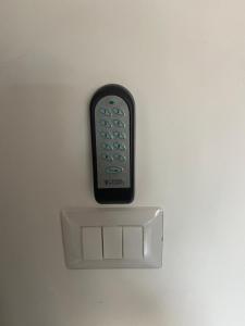 un telecomando seduto sopra un muro bianco di Casa vacanza Marily in centro, a 5 minuti dal mare ad Agropoli