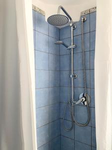 a shower in a bathroom with blue tiles at Waterfront Villa in Pantelleria