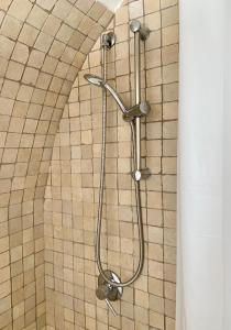 a shower in a bathroom with a tile wall at Waterfront Villa in Pantelleria