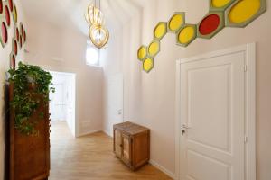 a hallway with a white wall with colorful art on it at Bellini Design Apartments in Naples