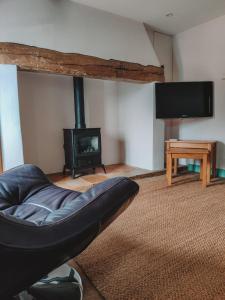 a living room with a chair and a fireplace at Alicias Cottage, Bacton in Norwich