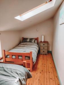 a bedroom with a bed and a wooden floor at Alicias Cottage, Bacton in Norwich