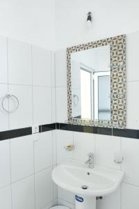 a bathroom with a sink and a mirror at Vila Orizzonte blue in Sarandë +80 photos