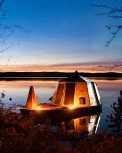 a small boat sitting on a lake at night at Peace & Quiet Hotel in Jokkmokk