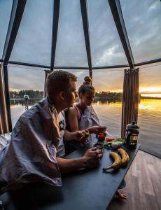 un hombre y una mujer sentados en una mesa en un barco en Peace & Quiet Hotel, en Jokkmokk