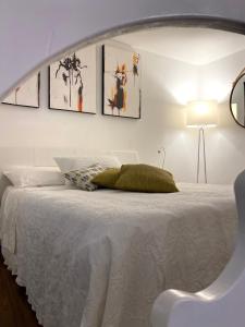 a white bed with a green pillow on it at La Verde di Vernazza - Art Studio - AC&WiFi - Vernazzarentals in Vernazza