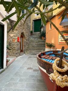a wooden boat sitting next to a building with stairs at La Verde di Vernazza - Art Studio - AC&WiFi - Vernazzarentals in Vernazza