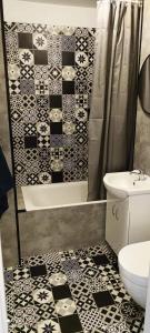 een badkamer met een douche, een toilet en een wastafel bij Apartament Fifi in Warschau