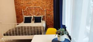een kleine slaapkamer met een bed in een bakstenen muur bij Apartament Fifi in Warschau