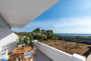 balkon ze stołem i widokiem na ocean w obiekcie Rizes Seaside Homes w mieście Vromonérion