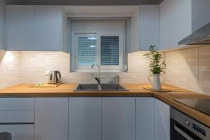 a kitchen counter with a sink and a window at Rizes Seaside Homes in Vromonérion