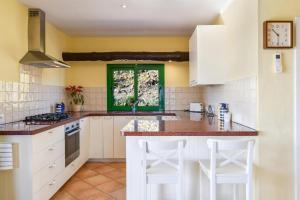 a kitchen with white cabinets and a green window at Casa Uva in Yaiza