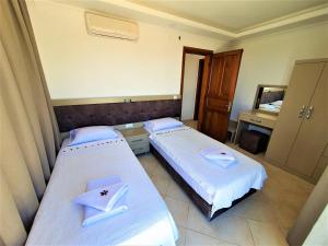 - 2 lits dans une petite chambre avec un miroir dans l'établissement Villa Asya, à Kalkan