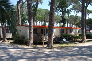 a house with a porch and a group of trees at Casa Mobile - Cisano San Vito **** in Calmasino
