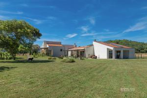 a house on a field with a grass yard at Le CaRaMeLle di Baratti in Baratti