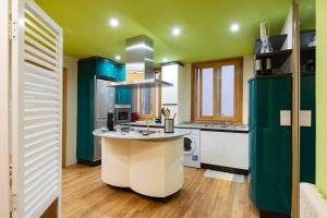 uma cozinha com paredes verdes e um balcão branco em Apartamento d'Angela- Pontevedra Centro em Pontevedra