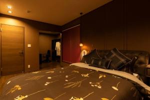 Un dormitorio con una cama con hojas. en Vacation Rental Motobu Grande BBQ機材完備の新築ヴィラ！！ en Motobu