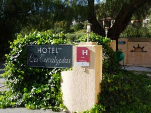 a sign for a hotel los angeles equals plus at Hôtel les Eucalyptus in Cavalaire-sur-Mer