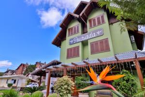 a building with a bird statue in front of it at Pousada Ares da Serra - Centro in Gramado