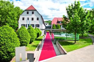 een rode loopbrug met vloerbedekking voor een huis bij Buhlsche Mühle in Ettlingen