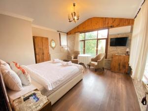 a bedroom with a large bed and a living room at Butik Hotel Maşukiye in Masukiye