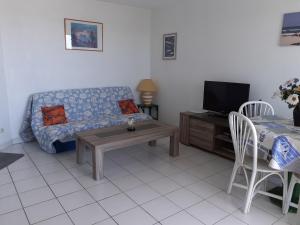 sala de estar con sofá y mesa en Appartement 1ère ligne très belle vue mer Rochelongue Cap d'Agde, en Cap d'Agde