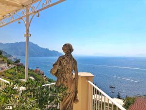 a statue of a woman standing on a balcony looking at the ocean at Residenza Al Pesce D'Oro in Amalfi