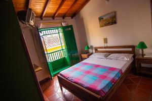 a bedroom with a bed and a green door at Hotel Cacique Chalalá in Charalá