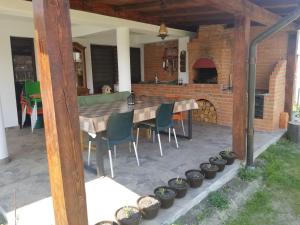 un patio con mesa, sillas y horno de ladrillo en Autentic Adorabil Apartment en Albeştii Pămînteni